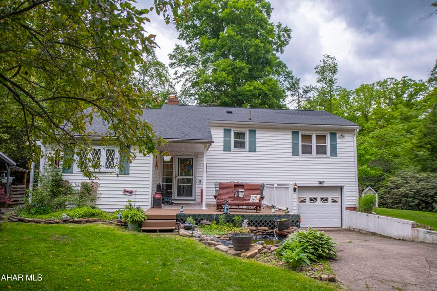 Split-level 3 bedroom home located on a private lot in Tyrone!  This home is situated on an approx half acre lot and features a large barn with a garage in the bottom and a storage area in the top that can be used for storage (currently used as a bar).  Inside the home you will find a large living room with vaulted ceiling and adjacent kitchen.  On the second level there are three bedrooms and a full bath.  The basement is partially finished and features a laundry / mechanical room as well as access to the 1 car garage.  The home also features a newer roof, newer oil furnace, partially fenced yard,and an outdoor furnace to keep your utility bills low!