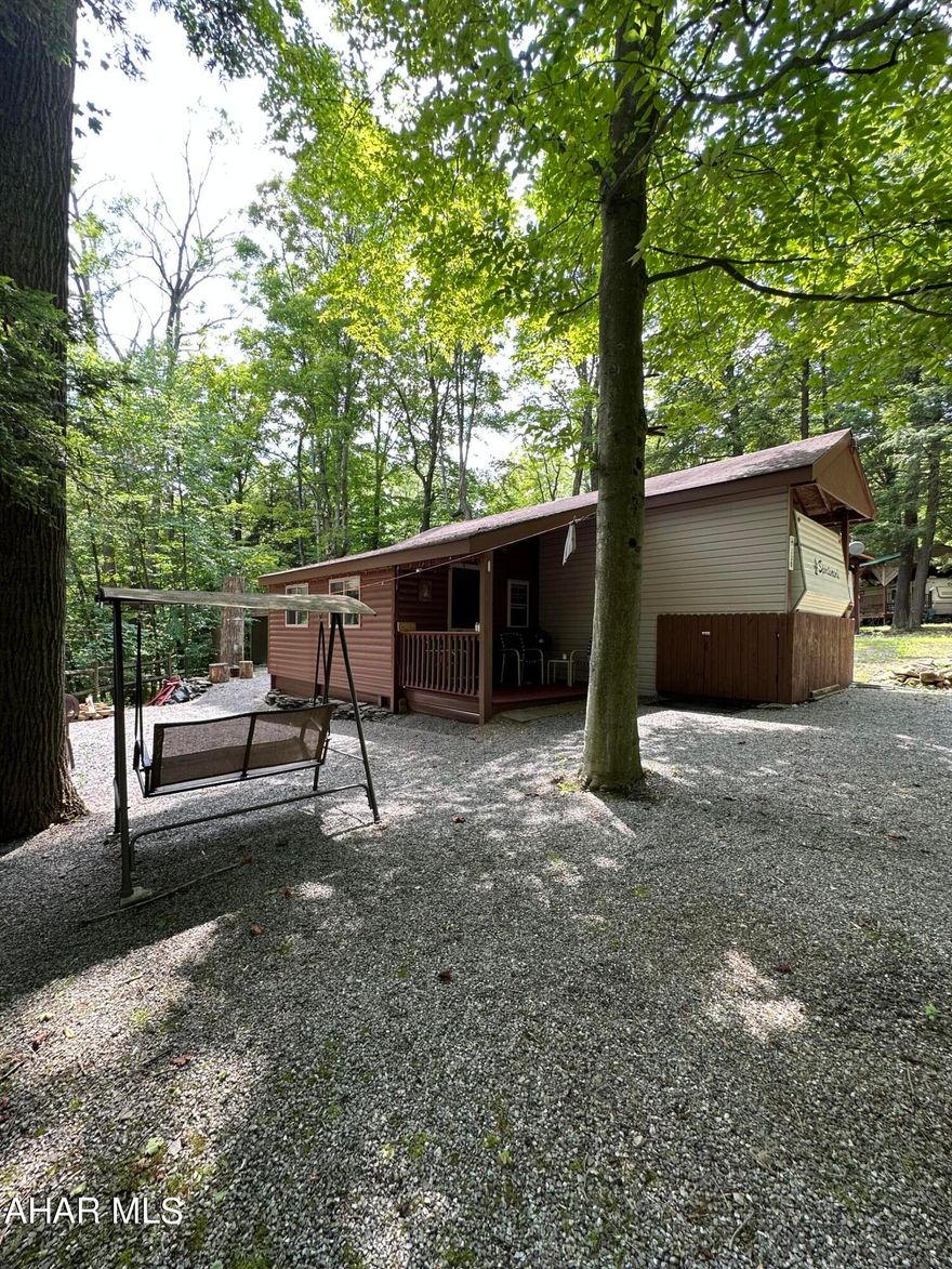 GLENDALE YEAROUND.....Camper on corner lot. 
Immaculate...offers A/C ....propane heat....full bath....eat-in kitchen.  The camper has a cabin section built on to create the living room!!  Privacey has been created with trees and being on a corner lot.  Enjoy the Fire Pit and lighting and night.  Shed is 10' x 12'..... new in 2020. puplic water and sewer.  Enjoy the pool and tennis courts. New tankless water heater...full 100 gallon propane tank.  POA dues are paid until end of year..will transfer to buyer!!