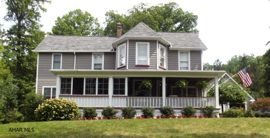 Charming historic home built in 1917 on apprx. 3/4 acre, surrounded by lush gardens with large fire pit & koi pond & custom designed outdoor private shower! Recently painted/newer roof. Circular driveway, very private setting. Carriage house style vinyl sided 2 car garage with workbench, built 2006.  Home has charming butler pantry with glass doors & shelves, hardwood floors upstairs too under the carpeting.  Custom window treatments throughout, handmade built ins (from England) in family room, stone fireplace, ceiling fans, large laundry room w/front loading washer & dryer right off the roomy & efficient custom kitchen w/ceramic tile floor. Large master suite, 2 full updated baths. Heat & central air in house/2 zones. 2800 sq. ft. living space.