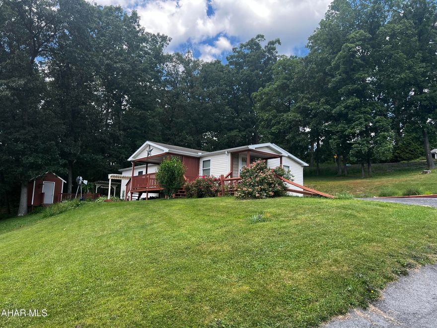 This immaculate home has been re-finished with dry wall, newer flooring, tile, and a completely upgrading kitchen. It features 2 bedrooms and a bonus room that can be used as a bedroom or utility room; as well as 2 full bathrooms. Enjoy sunsets on the covered front porch or entertain guests in the landscaped side space. This is a must see mobile home on leased land. Lot lease of $405/month includes trash removal.