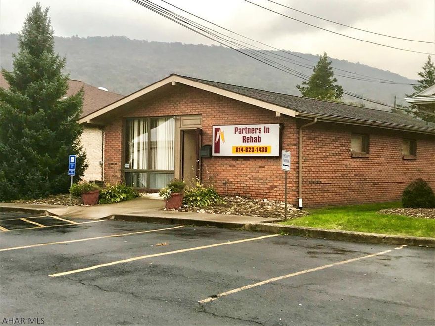 One-story brick office building containing 1,242 square feet with good visibility and exposure.  Building is in good condition and has a front macadam parking lot with spaces for five vehicles.  Interior has a reception area, three individual offices, mechanical room, half-bath, and the center section is open with a cathedral ceiling.  Heat pump with central air, 200-amp electric, updated electric water heater and security system. No basement, rests on a concrete slab.