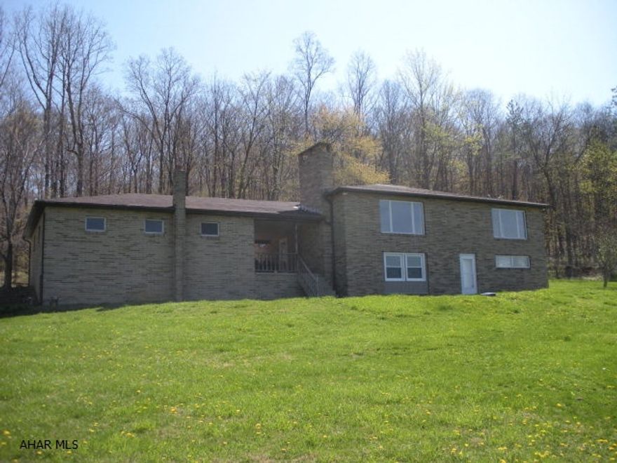 One of a kind Block & Brick home on 4.2 Acres in Frankstown Township close to Canoe Creek.  This unique home has a reverse floor plan for sleeping.  Main level is all hardwood in living/dining and bonus rooms.  The lower level is where the bedrooms are located all rooms have windows, newly installed carpet, and nice closets.  There are 2 fireplaces.  There is a 2 car garage connected by a breezeway.  Plus an above ground pool.  Property is located next to State Game Lands.