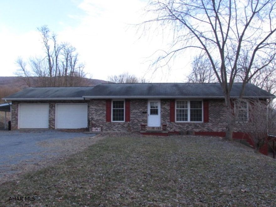 Great getaway rancher on 6.2 acres only 15 minutes from Lake Raystown - Snyder's Run boat launch.  3 bedroom, 2 baths plus lots of space in the lower level.  Nice layout/floor plan.  From the garage you enter the mudroom/laundry area then into the kitchen.  LR, DR, kitchen has open floor plan.  Lower level has a large rec area/family room, an office area, and bonus room.  Large patio at back.  Carport on the left of the home - for boat storage.  2-car garage.  Plus a workshop with garage doors that would fit ATV's or ski-doo's for the lake.  Wisteria Lane is a public road - well maintained by the county.  Great for a getaway or full-time residence - lots of possibilities!