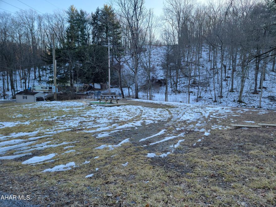 Partially wooded, 1.29 acre lot with stream on the outskirts of Tyrone. Newer storage shed. Electricity to the property. Water and sewer at the street.