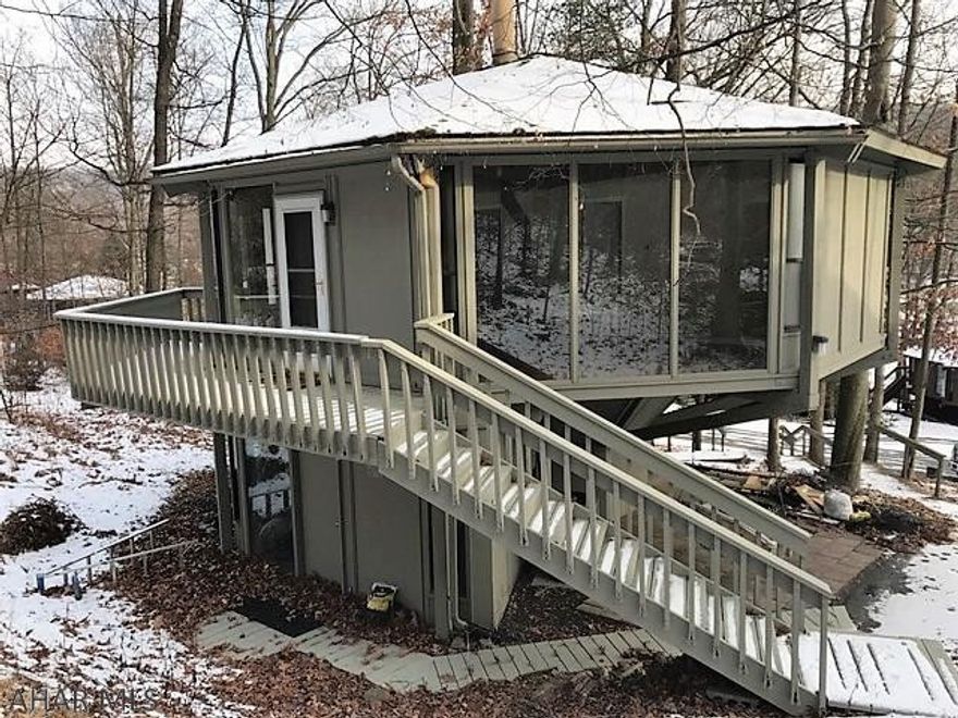This topsider home is just steps away from the Omni Bedford Springs Resort and Golf Course.  Tucked against the woods with a wraparound deck, patio and macadam driveway.  The interior is updated with newer cabinets, granite counters and stainless steel appliances.  Open living room with wood burner, two bedrooms, two baths and a recreation room (could be a 3rd bedroom).  Updated interior paint, heat pump with central air and 200-amp electric.