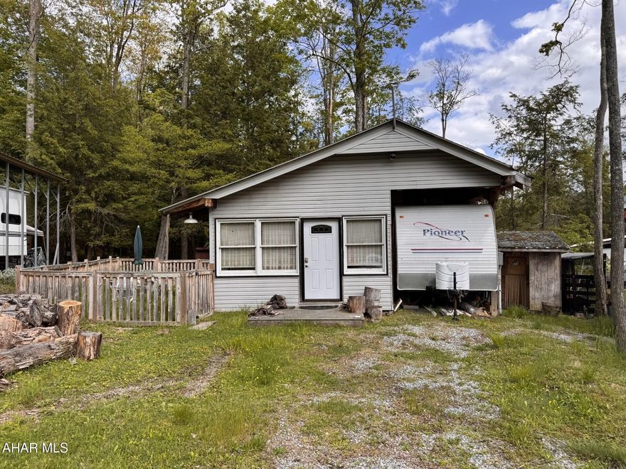 Fleetwood RV with approx.  15' x 27' addition with additional new cabinet space and woodburner for heat.  Partial fenced area.