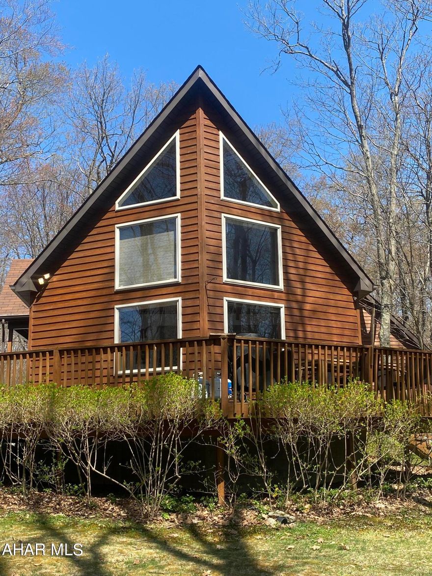 This TURNKEY A-frame cedar home is a charming and distinctive structure that graces the 7th hole of a golf course within a ski resort. The exterior of the house is clad in warm, natural cedar siding, blending seamlessly with the alpine surroundings. The sharply pitched A-frame roof is covered in rich, dark shingles, creating a striking contrast against the snowy backdrop in the winter and complementing the lush greenery during the warmer months.
Large, picturesque windows adorn the front of the house, offering panoramic views of the golf course and surrounding mountains. The windows also allow abundant natural light to flood the interior, creating a bright and inviting atmosphere. A spacious wooden deck extends from the front of the house, providing an ideal spot for residents and guests to enjoy the scenic beauty and perhaps even watch golfers teeing off or putting on the 7th hole. 
The cedar home embodies the perfect balance between modern comfort and rustic elegance, offering a serene haven in the midst of the ski resort's recreational amenities. Whether covered in a blanket of snow or surrounded by the vibrant greens of summer, this A-frame residence is a year-round retreat that captures the essence of mountain living. 
Endless opportunities, this is a successful TURNKEY Airbnb or could be a fully furnished Family home.
Everything is included with this  A-Frame cedar home located 5 mins from the Blue Knob Ski Resort. 3 bedroom, 2 full bath w/ bonus rooms in the basement to be bedrooms & game area/family rm.  Gas fireplace, EV charging station, larger detached 2 car garage with storage. Association fees $425.00 a year.  Close to 3 lakes Raystown, Shawnee & Indian. Close to Historic Downtown Bedford for shopping and fine dining.  Great hunting and fishing area.