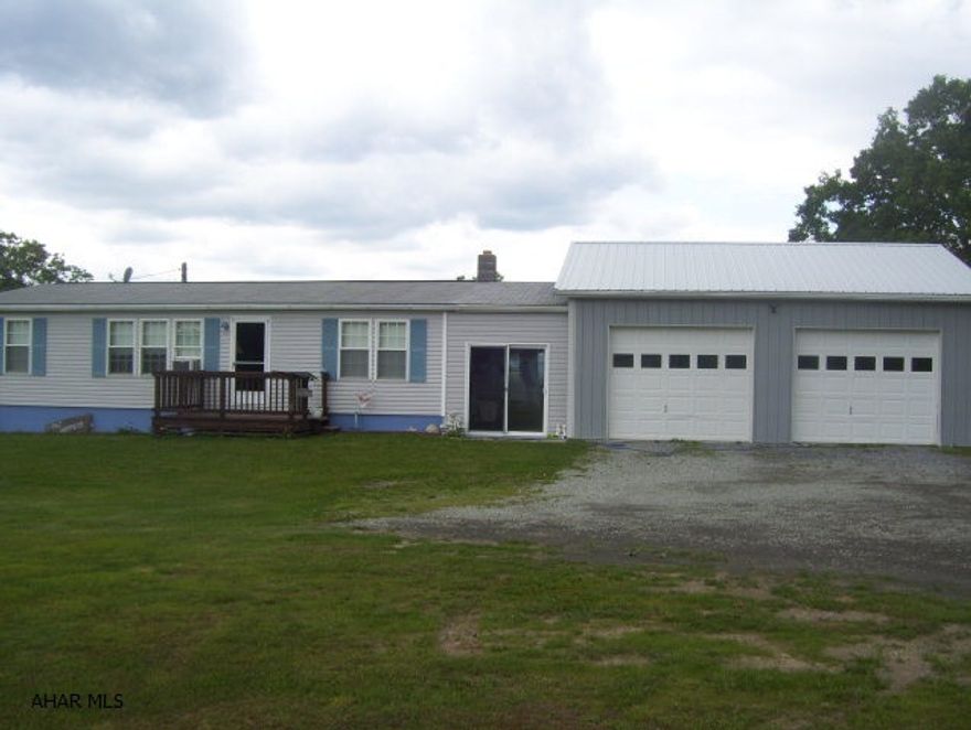 Well-maintained spacious double wide on foundation with partially finished basement and attached garage.  Great view on 5.09 acres.