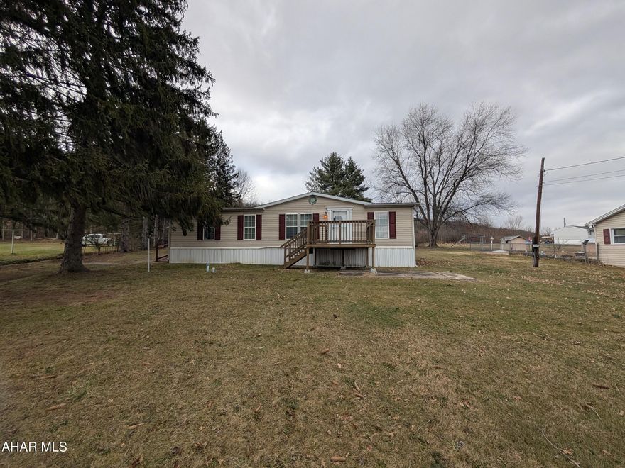 Hollidaysburg-area vinyl double-wide situated on a level half-acre lot! This well-designed home offers a fully equipped eat-in oak kitchen with a convenient laundry closet and separate dining area, plus a spacious formal living room ideal for entertaining. The primary suite features a relaxing hot tub, walk-in shower, and walk-in closet, complemented by two additional bedrooms and a full bath. An oversized one-car garage with a sub-panel provides ample space for a workshop—perfect for car enthusiasts or hobbyists.