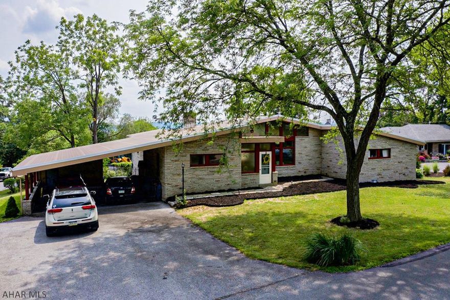 This is a one of a kind contemporary home located in Hollidaysburg right next to the Sylvan Hills Golf Course. The exterior of the home features cut stone and a new roof.  The interior of the home offers an open layout and features four bedrooms and three full baths.  There are two bedrooms on each side of the house with a open living / dining area area in the center.  A gas fire-pit is situated in the center of the living room.  The basement is unfinished with outdoor access. Outback is a spacious patio to relax with lots of privacy.  This property also offers an attached double-bay carport and a large driveway.