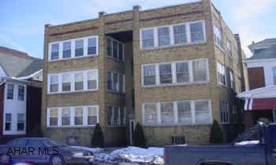6 unit brick apartment building, 2 rear aparments above the 5 detached garages.