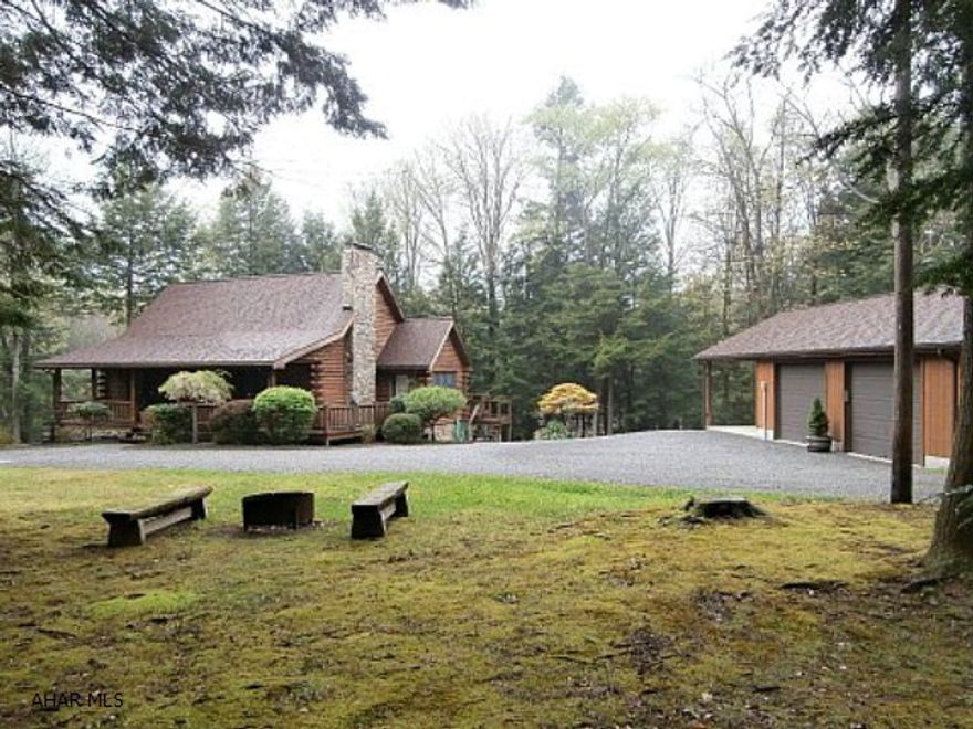 Fabulous wilderness log home on large wooded lot. Living room with fireplace/pellet stove insert. Vaulted beamed ceiling. Second floor loft bedroom with vaulted ceiling. Finished basement with large family room, bedroom and bonus room. Detached two car garage with attached carport. Shed. Rear deck and patio. Quality throughout. Very clean well maintained home. Electric storage heat.