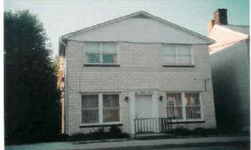 Two story, glazed block building plus 20'x40' garage building with partial second floor for storage. "Laundry Room" has hookups but no equipment. Three 2 Bedroom apartments 1st floor was occupied by owner and is the largest - 2 units ready to rent with minor updating.