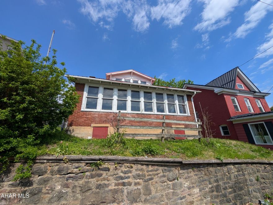 Juniata brick and vinyl 1.5 story is perfect for investors or handy persons. Metal roof and off street parking to rear. Home was duplexed at one time, but buyer to check city zoning if duplex is permissible. AS-IS sale, seller will make no repairs.  SECOND FLOOR EXTERIOR STAIRS ARE HAZARDOUS AND STRICTLY OFF LIMITS.