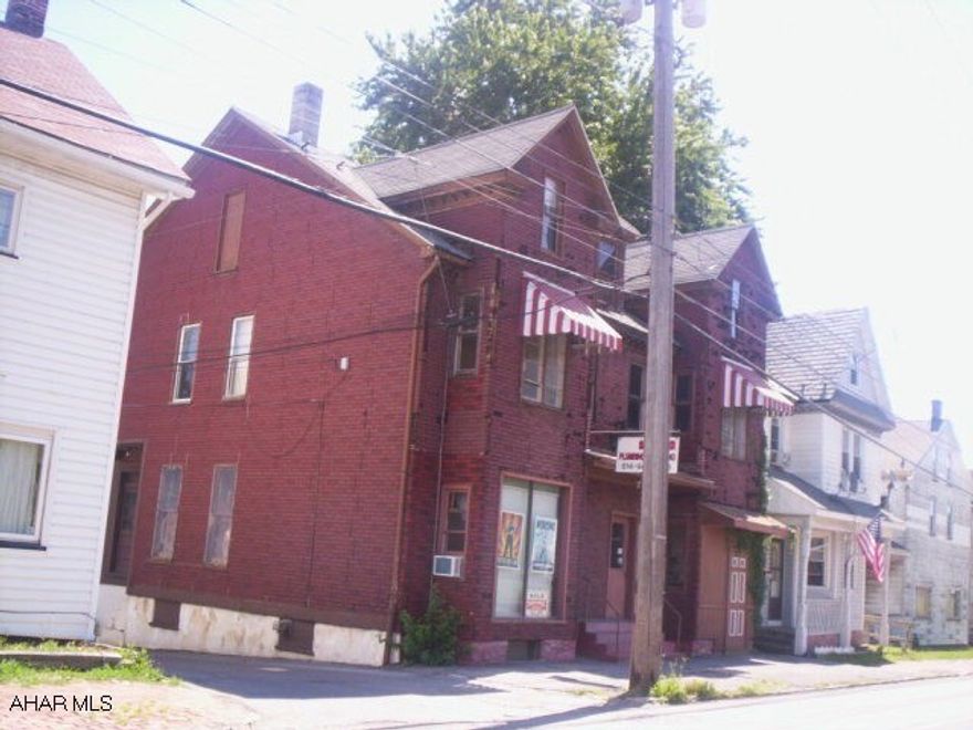 First floor currently used as plumbing shop.  Second floor apartment.  2 garage spaces, office area, storage area.  Building in need of repairs.  Several code violations.