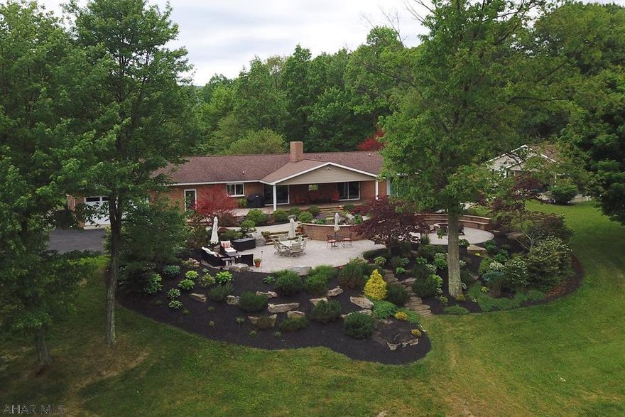 This incredible ranch home is truly above & beyond anything you have seen on the market! Located in a beautiful rural setting in Logan Twp the property spans 5 acres. Relax or entertain on the amazing custom-built patio by Tussey Landscaping. Huge outdoor space features a fire pit, professional lighting & landscaping with magical views overlooking property and surrounding nature.3 bdrms,2 baths, open floor plan & large windows throughout provide a ton of natural light. Step into this unique layout, where a gorgeous floor to ceiling fireplace stands as the centerpiece. Expansive kitchen boasts new quartz countertops & a rich marble backsplash. Bsmt partially finished for 2 bdrms, bath, & wet bar. Indoor pool, exercise rm, detached 2 car garage, addt'l building (office space) w/1 car garage.