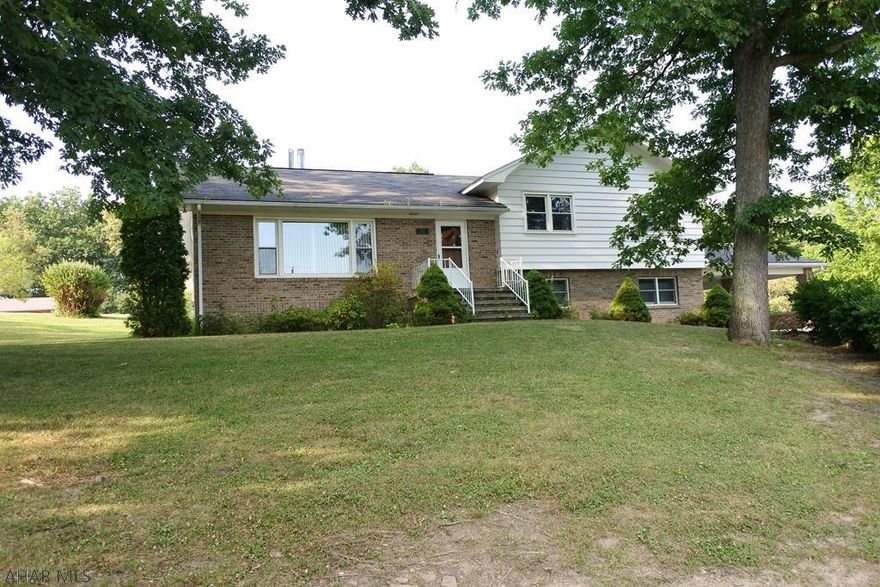 Spacious 1.16 acre lot with public sewer....multi-level home consisting of 3 BR's and 2.5 Baths, and bonus rooms on the lower level....plenty of space!!  The lower level needs a little TLC, but the location, hardwood floors and huge living room are real pluses!  Country feel, but only minutes from everything!  The cement carport can double as another patio in the Summer.  The rear covered patio is private and looks out over the rear yard. There is an unopened easement on the right side of the property to access a lot.