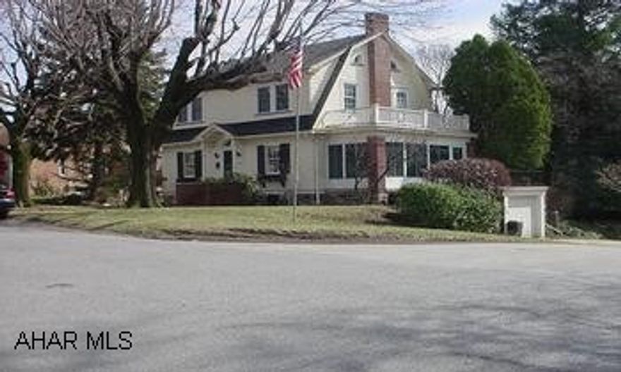 Charming Dutch Colonial. Large Living room with wood burning fireplace, book shelves, hardwood floors and French doors to 3 season porch.