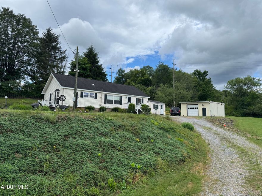 Beautifully maintained one story home containing 3 bedrooms, living room with pellet stove, equipped kitchen, laundry room with washer and dryer, and two baths. Front and side deck. Central air and a security system. Included is an outbuilding, formerly used as an office with phone, cable, elect. and propane heater. The garage is a pole type and measures approximately 24x30.  Very clean home on a nice lot. Double Wide with retired title.