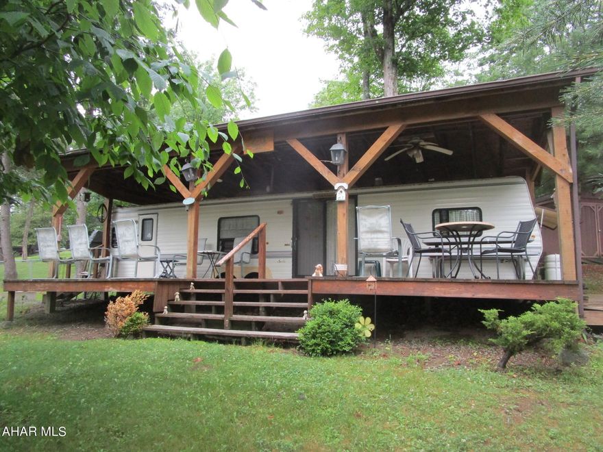 Two bedrooms sleep six in beds.  There is room for more to sleep in the living room / kitchen area.  Covered deck looking over the adjacent playground means mom and dad (or grandma and grandpa) can relax at camp while keeping a close eye on the children playing nearby.  Storage shed and fire pit included.