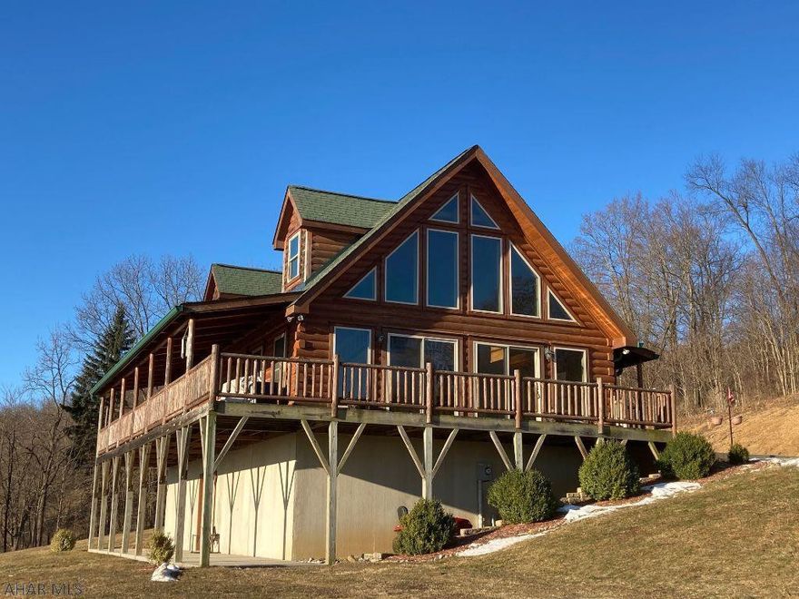 Log home on more than 4.5 acres. Open concept kitchen and great room with cathedral ceiling. Master bedroom and master bath on first floor. Additional first floor bedroom and full bath. Loft, 3rd bedroom and full bath on 2nd floor. Entire interior is pine. Nice covered front porch with wrap around side deck. Full basement with walk out patio door to a lower level covered patio. Superior wall construction and geothermal heat pump for heating and cooling makes this a more efficient and desirable home. Basement is plumbed for a 4th bathroom.  Stunning property with amazing view of the cove and mountains.