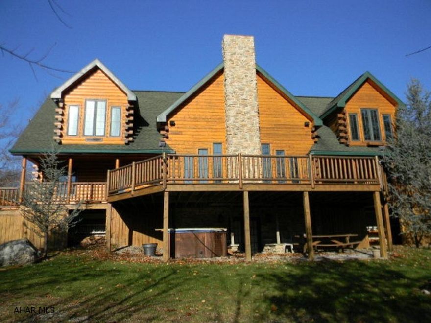 Custom 3200 square foot log home with four car garage built with exceptional quality for the most discriminating buyer. An impressive 2-story stone fireplace flanked by a wall of windows takes in gorgeous views and stunning outdoor living space. A huge deck, patio, in ground pool, terrace and hot tub make vacations a thing of the past. The huge master retreat comes complete with private seating area, soaring ceilings, bathroom w/Jacuzzi tub and fireplace. The master shares a loft with its own stone/granite mantel and high end wood stove. French doors lead to another huge bedroom upstairs while downstairs enjoy another two bedrooms and bath. A custom built recreation room has to be seen to be appreciated. Please watch the visual tour to see the value!