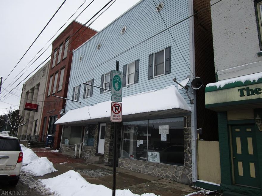 2 store fronts with garage and storage on 1st floor. Three apartments on the second floor. Apartments currently rented at $500, 500, 400. Store fronts vacant - could be 2 separate fronts. Rubber roof is 10 years old. Most windows replaced. Coal hw boiler in basement. Rewired. Separate electric.4 car parking at rear and street parking in front. Great opportunity to run your business and get income from the apartments.