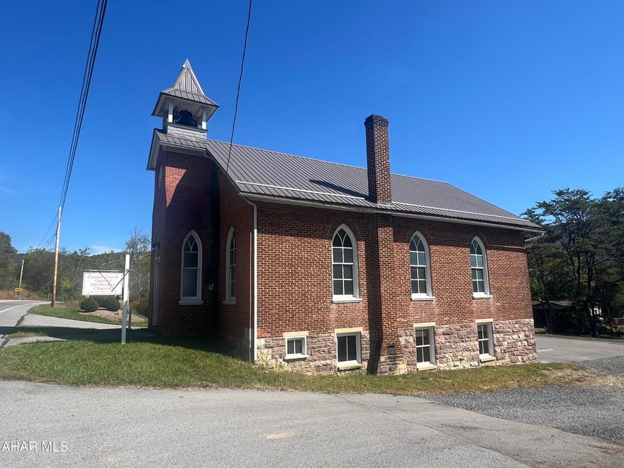 Discover a unique opportunity along the high-visibility Route 22 corridor in Frankstown Township, Blair County. Built circa 1921 and situated on approximately 0.29 acre, this 1,395-square-foot brick and mountain stone building combines historical character with modern updates. The property is zoned M-F (Manufacturing-Farming District) within the Hollidaysburg Area School District, offering a range of potential uses for a discerning buyer or investor.

Step inside through double raised-panel wood doors into a welcoming foyer featuring two stained glass windows, a hanging light, bell rope, and access to the main sanctuary. The sanctuary showcases timeless craftsmanship with oak floors, carpet runners, 20 wood pews, two ceiling fans, and eight cathedral-shaped stained glass windows. The raised pulpit area includes a communion rail, pulpit furniture, and a Hamilton piano, creating a warm and authentic setting. From the pulpit, stairs lead to the finished lower level, which also has an exterior entrance and handicap-accessible ramp. The lower level features two newly constructed ADA-compliant restrooms, a new drywall ceiling, a furnace room with a 275-gallon oil tank, nine windows, and an exterior door leading to the paved parking lot.

The property is served by a new well and a 2,000-gallon holding tank. Systems include a 100-amp breaker panel and a Luxaire oil forced hot air furnace. The exterior has been recently improved with a new metal channel-drain roof, vent ridge, spouting, snow guards, and a bell tower. Additional exterior highlights include concrete steps with vinyl handrails, a vinyl signpost, security lighting, and direct driveway access from US Route 22.

Located just minutes from Historic Hollidaysburg, Canoe Creek State Park (958 acres), the Frankstown Branch of the Juniata River, and State Game Lands #147 (9,254 acres), this property offers a versatile setting ideal for a small business, studio, workshop, community use, or adaptive reuse project. Its blend of craftsmanship, visibility, and rural charm makes it a truly special property in Central Pennsylvania.