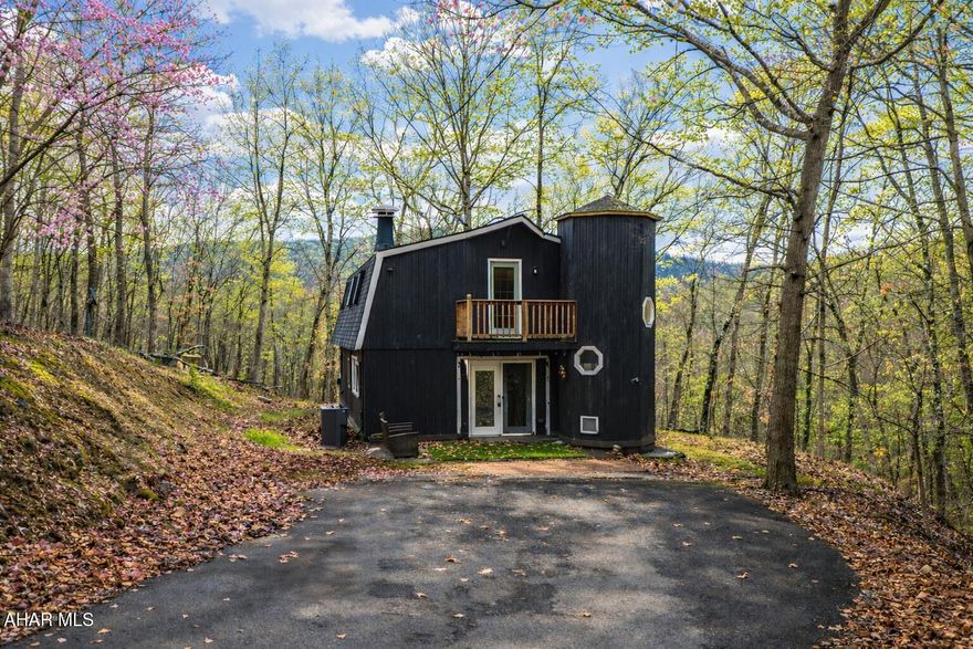 Experience custom craftsmanship paired with country living in this unique approximately 2,154 sq. ft. home. Sitting on over 10 wooded acres, this property is great for those who love outdoors. It features a cleared food plot for the avid hunter and a second-floor balcony perfect for morning coffee, tea, or protein shake while watching wildlife or soaking in the view. A set of double-entry doors welcomes you into a completely open-concept first floor, where modern luxury meets rustic charm. You'll find durable, waterproof luxury vinyl flooring throughout, beautifully complemented by warm pine wood accents.

The heart of the home is a newer kitchen--a chef's dream featuring butcher block countertops and a deep farmhouse-style sink. Bathed in natural light from two massive bay windows, the living area centers around a magnificent stone-front wood-burning fireplace, while a spiral staircase serves as a striking architectural characteristic.

Designed for modern comfort, this 3-bedroom, 2.5-bathroom home includes a private master bedroom, and updated ensuite master bathroom that has a stand up shower. You'll enjoy total peace of mind with a new furnace and a new water heater already in place. The location is unbeatable for both convenience and leisure: situated approximately 5 minutes from the historic Jean Bonnet Tavern, 10 minutes from I-99, and only 15 minutes from the world-class Omni Bedford Springs Resort and the PA Turnpike.