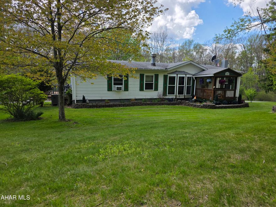 Welcome to 432 Black Snake Road in Dysart, where peaceful country living meets everyday convenience. Situated on 1.75 partially wooded acres that directly border State Game Lands, this property offers a rare opportunity to enjoy privacy, nature, and abundant wildlife right in your own backyard PLUS you'll have easy access to fishing, boating, camping, and outdoor recreation located just 15 minutes from Glendale Lake.

Step inside to a warm and inviting living room featuring a wood-burning fireplace and beautiful bay windows that fill the space with natural light while creating a cozy, country atmosphere. The kitchen provides generous storage with solid oak cabinetry and a pantry, and all appliances are included for added convenience. Just off the kitchen, you'll find a dedicated laundry room complete with washer and dryer and pantry storage.

The spacious primary suite is designed for comfort, offering a large walk-in closet and a private bath with a garden tub, separate shower, and vanity area. A versatile den or office space provides flexibility for work or relaxation, featuring French doors for privacy and sliding glass doors that lead directly to the deck.

Outdoors, the property truly shines! Enjoy the beauty of mature trees, perennials, and fruit trees throughout the landscape. The oversized wraparound back deck is perfect for entertaining or unwinding, complete with remote-controlled retractable awnings so you can comfortably take in the surrounding views and wildlife.

The full basement includes a deep two-car integral garage and ample storage space. Additional outbuildings, including a shed and a carport/garage, provide even more room for vehicles, recreational equipment, or hobbies.

If you've been searching for a private retreat that balances natural surroundings with accessibility, this property is ready to welcome you home.