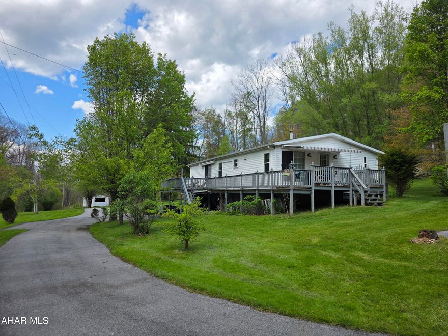 Welcome to 432 Black Snake Road in Dysart, where peaceful country living meets everyday convenience. Situated on 1.75 partially wooded acres that directly border State Game Lands, this property offers a rare opportunity to enjoy privacy, nature, and abundant wildlife right in your own backyard PLUS you'll have easy access to fishing, boating, camping, and outdoor recreation located just 15 minutes from Glendale Lake.

Step inside to a warm and inviting living room featuring a wood-burning fireplace and beautiful bay windows that fill the space with natural light while creating a cozy, country atmosphere. The kitchen provides generous storage with solid oak cabinetry and a pantry, and all appliances are included for added convenience. Just off the kitchen, you'll find a dedicated laundry room complete with washer and dryer and pantry storage.

The spacious primary suite is designed for comfort, offering a large walk-in closet and a private bath with a garden tub, separate shower, and vanity area. A versatile den or office space provides flexibility for work or relaxation, featuring French doors for privacy and sliding glass doors that lead directly to the deck.

Outdoors, the property truly shines! Enjoy the beauty of mature trees, perennials, and fruit trees throughout the landscape. The oversized wraparound back deck is perfect for entertaining or unwinding, complete with remote-controlled retractable awnings so you can comfortably take in the surrounding views and wildlife.

The full basement includes a deep two-car integral garage and ample storage space. Additional outbuildings, including a shed and a carport/garage, provide even more room for vehicles, recreational equipment, or hobbies.

If you've been searching for a private retreat that balances natural surroundings with accessibility, this property is ready to welcome you home.