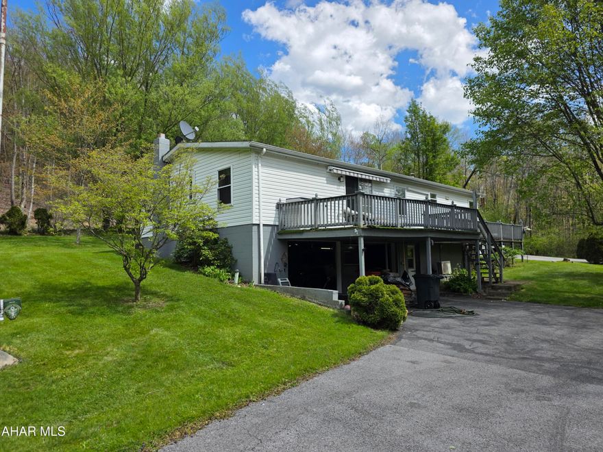 Welcome to 432 Black Snake Road in Dysart, where peaceful country living meets everyday convenience. Situated on 1.75 partially wooded acres that directly border State Game Lands, this property offers a rare opportunity to enjoy privacy, nature, and abundant wildlife right in your own backyard PLUS you'll have easy access to fishing, boating, camping, and outdoor recreation located just 15 minutes from Glendale Lake.

Step inside to a warm and inviting living room featuring a wood-burning fireplace and beautiful bay windows that fill the space with natural light while creating a cozy, country atmosphere. The kitchen provides generous storage with solid oak cabinetry and a pantry, and all appliances are included for added convenience. Just off the kitchen, you'll find a dedicated laundry room complete with washer and dryer.

The spacious primary suite is designed for comfort, offering a large walk-in closet and a private bath with a garden tub, separate shower, and vanity area. A versatile den or office space provides flexibility for work or relaxation, featuring French doors for privacy and sliding glass doors that lead directly to the deck.

Outdoors, the property truly shines! Enjoy the beauty of mature trees, perennials, and fruit trees throughout the landscape. The oversized wraparound back deck is perfect for entertaining or unwinding, complete with remote-controlled retractable awnings so you can comfortably take in the surrounding views and wildlife.

The full basement includes a deep two-car integral garage and ample storage space. Additional outbuildings, including a shed and a carport/garage, provide even more room for vehicles, recreational equipment, or hobbies.

If you've been searching for a private retreat that balances natural surroundings with accessibility, this property is ready to welcome you home.