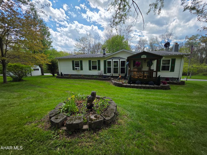 Welcome to 432 Black Snake Road in Dysart, where peaceful country living meets everyday convenience. Situated on 1.75 partially wooded acres that directly border State Game Lands, this property offers a rare opportunity to enjoy privacy, nature, and abundant wildlife right in your own backyard PLUS you'll have easy access to fishing, boating, camping, and outdoor recreation located just 15 minutes from Glendale Lake.

Step inside to a warm and inviting living room featuring a wood-burning fireplace and beautiful bay windows that fill the space with natural light while creating a cozy, country atmosphere. The kitchen provides generous storage with solid oak cabinetry and a pantry, and all appliances are included for added convenience. Just off the kitchen, you'll find a dedicated laundry room complete with washer and dryer and pantry storage.

The spacious primary suite is designed for comfort, offering a large walk-in closet and a private bath with a garden tub, separate shower, and vanity area. A versatile den or office space provides flexibility for work or relaxation, featuring French doors for privacy and sliding glass doors that lead directly to the deck.

Outdoors, the property truly shines! Enjoy the beauty of mature trees, perennials, and fruit trees throughout the landscape. The oversized wraparound back deck is perfect for entertaining or unwinding, complete with remote-controlled retractable awnings so you can comfortably take in the surrounding views and wildlife.

The full basement includes a deep two-car integral garage and ample storage space. Additional outbuildings, including a shed and a carport/garage, provide even more room for vehicles, recreational equipment, or hobbies.

If you've been searching for a private retreat that balances natural surroundings with accessibility, this property is ready to welcome you home.