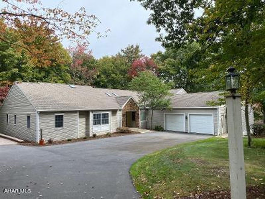 HOLLIDAYSBURG - STONEHEDGE Bigger than it looks! Beautifully updated sprawling 4000+/- total sq foot 3-4 bedroom, 3.5 bath ranch for convenient one story living! Private 1.45 ac lot is one of few homes in Stonehedge with public water service! Skylights, walls of windows and Sunroom allow light to flow with view of wildlife and mature landscape on tree lined lot.  En suite Master dressing area and bath has heated floors, new separate vanity area, his and her walk-in closets, jetted soaking tub plus shower, and 2nd vanity for total of 2 1/2 baths on main level plus 3/4 bath on lower level. Eat in L shaped kitchen has stainless appliances, hood vent with double fans, plus granite island suitable for dining as well as prep and serve for entertaining, a second sink near dining room for wet bar. Updates between 2012-21 roof, skylights, furnace, hot water heater, furnace, 2nd ac unit as well as new all new hardwood and tile flooring throughout, cabinets, hard surface and granite counters in kitchen and baths. Formal dining room has French doors and family room with fireplace has pocket doors to formal living room for entertaining or privacy.  The 4th bedroom space is currently set up as an office with wall of bookcase & desk/workspace but can be converted back by adding double doors and switch bookcase for closet. Off kitchen oversized Laundry/Mudroom/Pantry/Storage area with 2nd refrigerator, utility sink and desk area for tidy and efficient home management. Semi-finished lower area has 3/4 bath and room to add a Recreation Room, Theatre, Game and/or Exercise room. Ask about custom interior painting, you pick colors! Don't miss this one!