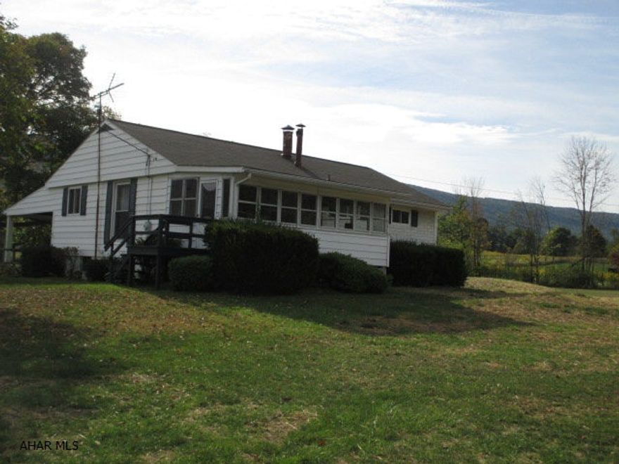 So much to offer in this 1 story, 3 bedroom home in country.  Includes enclosed front porch, original oak hardwood floors, covered porch, 2 car garage plus garage & workshop (42X24).  Brand new (green) fresh water septic system all on beautiful 1.15 acres with apple & pear trees.