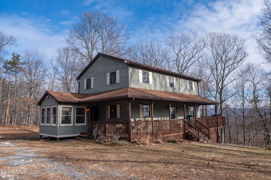Warm, inviting home set on 9.278 wooded acres in Monroe Township, offering privacy and a true mountain retreat feel. The interior features extensive natural wood finishes, including tongue-and-groove walls and ceilings, creating a cozy lodge-style atmosphere throughout. The open main living area showcases soaring ceilings, abundant natural light, and access to expansive wraparound decking—ideal for enjoying the peaceful surroundings and seasonal views. The kitchen offers ample cabinet space and a functional layout, while the home includes three bedrooms and two full bathrooms. Multiple decks and outdoor areas enhance the setting, making this property well-suited for full-time living, a second home, or a weekend getaway.