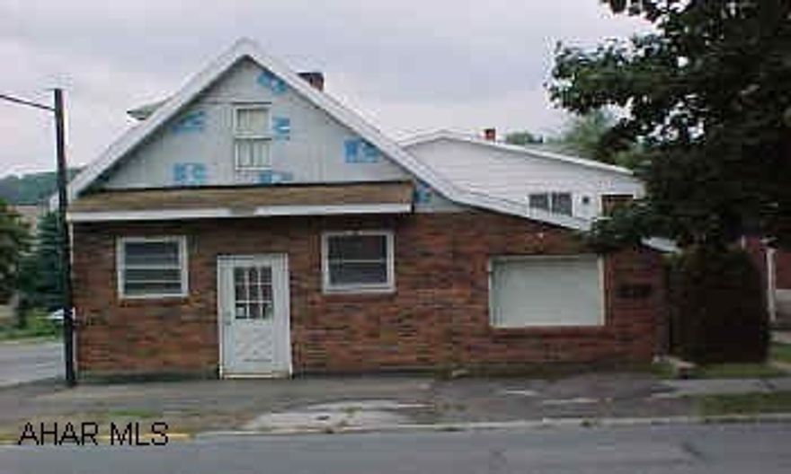 zoned multi-dwelling. Vacant corner store front with rear 2 bedroom apartment and integral garage.