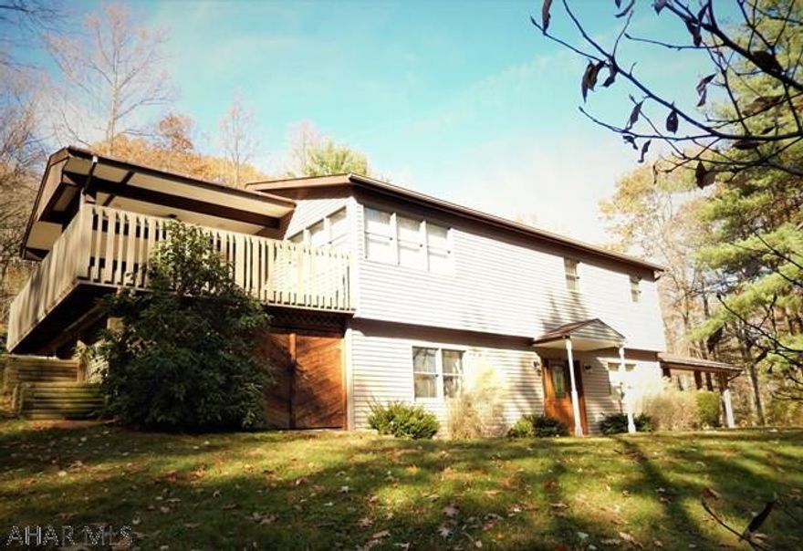 Pristine raised ranch style home, secluded in Sinking Valley on 4.5 acres, with  fenced Tennis court and Gazebo W/ electric! The Large Deck off the Dining Room is partially covered W/ ceiling fan for cool shade  and partially open to enjoy the sun. Many perennial gardens. Updated kitchen and bath with beautiful tile work. Includes stainless steel appliances. Living Room with many windows to enjoy the view. Family room with fireplace (propane). 2 Heat sources: Heat pump for heat and central air, plus hot water oil furnace. The gravel lane has a motion light to a large paved driveway, carport and garage.  You must see this lovely setting! This house is well taken care of and move-in ready!