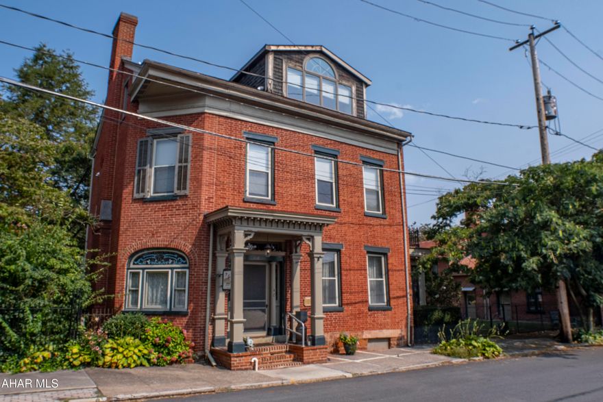 Mimosa Courtyard Inn — Three-Building Homestead & B&B in the Heart of Historic Hollidaysburg

418 N Montgomery St, Hollidaysburg, PA 16648

Where history, hospitality, and opportunity meet. Set just off the Diamond—Hollidaysburg's historic town square—this storied brick residence (c. mid-19th century) anchors a walled garden courtyard and is being sold with two additional companion structures: a converted guest cottage/apartment and a garage with open workshop. Together, the trio creates a flexible, multi-building compound perfect for a generational homestead, boutique inn/Airbnb operation, live-work creative space, or all of the above. The property has long welcomed travelers as the Mimosa Courtyard Inn, a well-reviewed B&B known for its period charm and serene courtyard