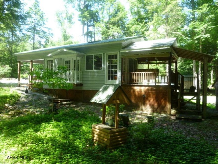 Charming and elegant are two words to describe this snug getaway.  Surprises and extras are at every turn starting on the exterior.  Whether you are walking outside discovering the flora and fauna that surround this hideaway or sitting on the cozy deck overlooking the stream you will feel refreshed from the experience.  Although located in a wooded camping area, when you step into the upgraded park model with an added living room/dining room you will feel pampered.  Two bedrooms, a spacious eat in kitchen with cabinets and countertops already loaded with cooking and eating equipment.  Step down into the living area and be delighted with the dcor.  Pass through the French doors to the back deck.  Sit on the swing and watch the water wheel or wait for a deer or chipmunk to happen by.