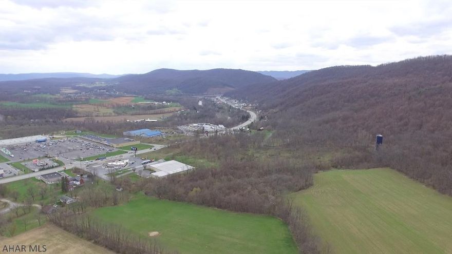 Click video for drone video! 193+/- acre parcel of land with public water and sewer available. This commercially zoned property has 275 feet of road frontage along high traffic route Route 30 (Lincoln Highway) & is located across from Walmart, McDonald's, Weis Grocery Store and Tractor Supply. It is ideal for a retail, service oriented business, housing development with spectacular views and/or restaurant. The upper land includes farmer fields as well as wooded acreage. The property includes a large pole building presently leased as well as a residential home which is also rented. Both leases are on a month to month basis. Property is located at one of Bedford's busiest intersections which makes a tremendous opportunity to take advantage of the business potential in this growing community.