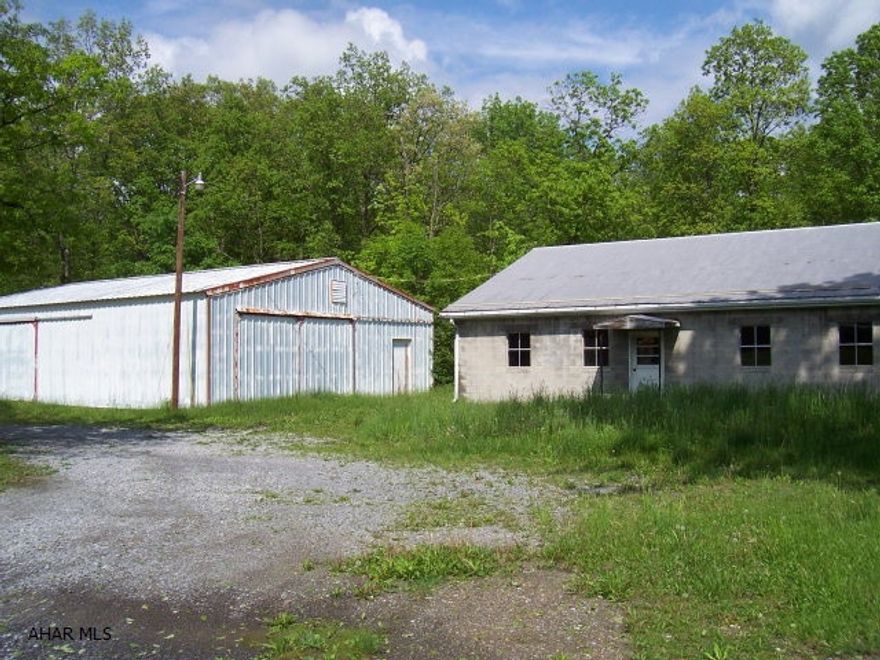 Building 1 is approx. 30x60, 2,280 sq.ft. concrete block building on concrete.  Metal roof, aluminum gutters, single pane windows,electric, 1/2 bath, industrial coal-burning stove, and attic for storage. 6 rooms and second FL attic. Private well. City sewer available tap fee to hook on. Building 2 is approx. 40x60, 2,560 sq.ft metal building on concrete slab. Used for storage. Has public electric. Damage to concrete floor.