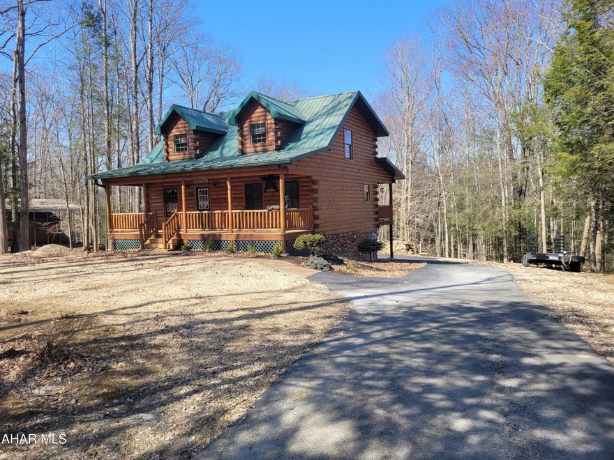 Exquisite:  one word to describe this log home property.  Built in 2007 with many updates done by the current sellers.  All new cabinets and granite counter tops in the kitchen, new memory foam mattresses for the beds, new light fixtures throughout the home and bathrooms updated inside.  Landscaping and expansion of the driveway outside are just some of the improvements made in the last two years.
Full length covered porches in the front and back of the home.  The back deck is partially screened in.  A paved driveway extends from the road around the back of the home to the detached oversized garage which also has a 12' x 26' storage loft.  An integral  garage bay at the house gives you room for more than three vehicles. Just below the garage is a private, professionally landscaped patio / fire pit area.
Much of the furniture that makes this home so inviting is staying.  The living room is open to the kitchen for easy entertaining.  The main floor bathroom also contains the laundry for convenience.  A first floor bedroom means no steps.
Upstairs in the loft there is a huge sleeping area, a 3/4 bath and a sitting area.  
Downstairs offers a separate area for relaxing or extra sleeping space for guests.  
Sit outside on one of the porches or fireside.  When the weather is cold, come in and cozy up in front of one of the supplemental fireplaces.