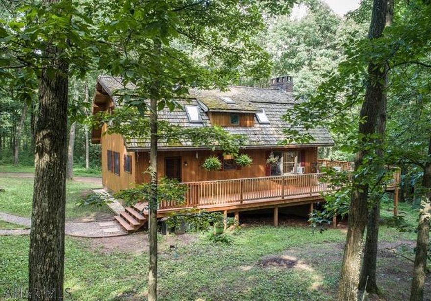 Surrounded by mature woods sits this custom cedar home perfectly situated on 22 secluded acres.  Inside, one feels as if they are sitting in an natural oasis as the interior cedar walls expand beyond through the many huge windows and large decks surrounded by everything nature.  A soaring brick floor to ceiling fireplace surrounded by glass adds a wow factor to the home.  Custom oak floors with cherry pegs, solid wood doors and cedar interior and exterior walls are just a few of the many outstanding features.  A 832 sq.ft. garage or workshop completes this property.  Click on visual tour to see drone footage.