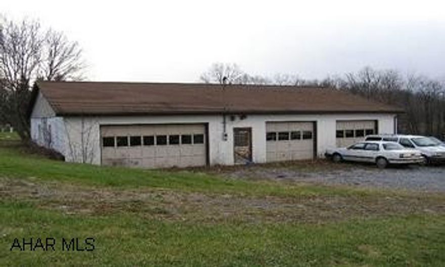 One Story  2,400 sq. ft. cement block building with 3 overhead doors, concrete floor, 100 amp service, access to public water and sewer. 2 overhead doors 8'x10', 1 - 8'x16' Ideal for classic / antique auto or inventory storage. Suitable for small business.