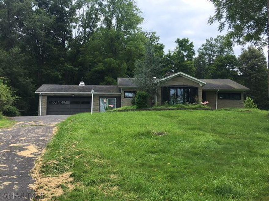 Ranch in private setting on more than 2 acres yet very close to town. Hardwood floors, 2 car garage, stone exterior. New roof. Excellent price. Being sold AS-IS.