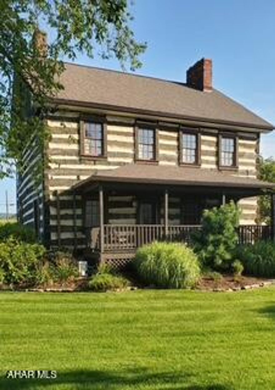 Now's your chance to own a piece of history with this pre 1800 original log home.  Originally owned by the Todd Family, this property has been called home by many over the years but most recently housed a charming gift shop until it closed in July of this year.  Although the house is move in ready, it would also make a great business location for a brewery, winery bed and breakfast, garden themed business
the possibilities are endless.
This property is located at the intersection of Routes 30 and 56 and sits next to the Bedford County Historical Society.

The charm of the house starts outside with the beautiful log and chink exterior, divided light windows with front and rear porches.  To complement the exterior, the house is surrounded by pretty gardens, a stone patio and a stone walkway.  There are also three outbuildings including a three car garage with loft, a cute cottage that would be the perfect She Shed or Man Cave and a barn with loft for additional storage.

The house boasts a custom kitchen with locally built hickory cabinets that are stained in a deep walnut and feature soft close drawers and pullouts; granite countertops add a rustic feel along with the beautiful farm sink.  Keeping with the historic feel of the house, the owners chose a vintage replica stove from Elmira Stove Works that feature a natural gas cooktop and electric oven.   The entire first floor features custom made random width hickory floors that were also made locally.  There are three stone fireplaces on the first floor that have been upgraded to burn wood, although they could easily be converted to gas logs.  The first floor bathroom features a shower stall unit, updated toilet and rustic vanity.

The second floor features three nice sized bedrooms with custom shutters and closet doors.  The second floor bath features a clawfoot bathtub, updated toilet, tile floor and rustic vanity.  There is also a full basement with washer/dryer hookups and a walk-up attic for additional storage