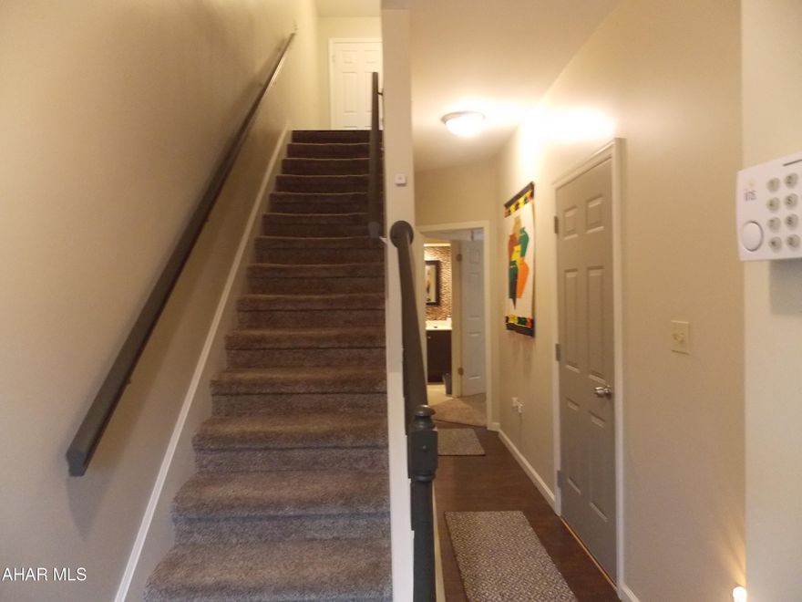 Stunning and spotless is how to describe this townhome in a  beautiful peaceful neighborhood in Altoona.  Close to I 99, as well as tons of shopping and restaurants makes this home in a very  convenient location.  Turn off of Ruskin Drive onto Beckman and look for 127, the For Sale sign is in the window on the second floor.
Walking in on the lower level you will find the laundry a 3/4 bath with stonework around the sink and a bedroom. as well as access to the garage. This is a perfect spot for guests so they have privacy and their own bath. Could also be a den, gym or a home office.  Off of this bedroom is a patio to sit and relax. What a surprise you will have when you walk upstairs and see the spacious open LR/DR with a custom stone wall where the TV is mounted and beautiful floors. (TV does not stay) This is a great space for entertaining and the large windows bring in lots of light and sunshine.
The kitchen has granite counters, a bar to eat  breakfast  and lovely cabinets. Off of the kitchen is a covered deck that looks over the lush green landscaping. Just imagine drinking your morning coffee here, it is so peaceful and quiet. There is also a half bath on this level with more custom stone work on the wall.
The third level has two large bedrooms.  One with a walk in closet and the other with 2 closets.  The shared bathroom has pocket doors separating the two sinks so each Bedroom has their own sink.  More custom stone work in the bath too.
What a perfect home no HOA fees and everything has been updated. Nothing to do but move in! Give us a call to see all this home has to offer. 
 OPEN HOUSE Sunday June 2nd, 1-2:30