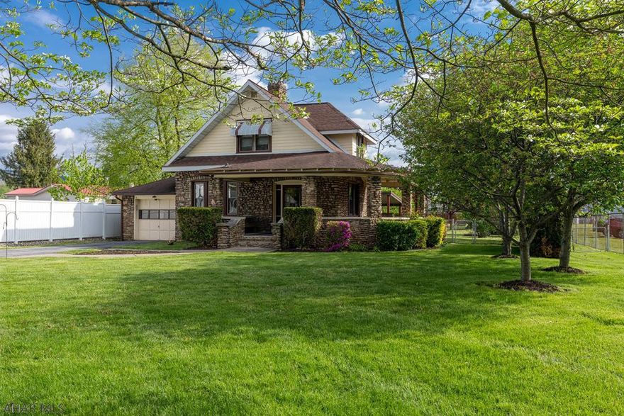 Cool cobblestone home with wrap around front porch. This home has 3 bedrooms and 2.5 baths. Beautiful new kitchen with stainless appliances. The main living area has newer laminate floors and a fireplace. The dining room has recessed lights. Open to the kitchen is a gathering room. The first floor also has a powder room. The main bedroom has 2 large closets and a built-in desk and makeup area. Enjoy the large, rear fenced yard and large covered patio. There is an additional lot that is 69x71.2 that is included within the fenced area. 1 car attached garage. Plenty of off street parking and great views of the fireworks on July 4th. Photos taken by Two 20 Studios.