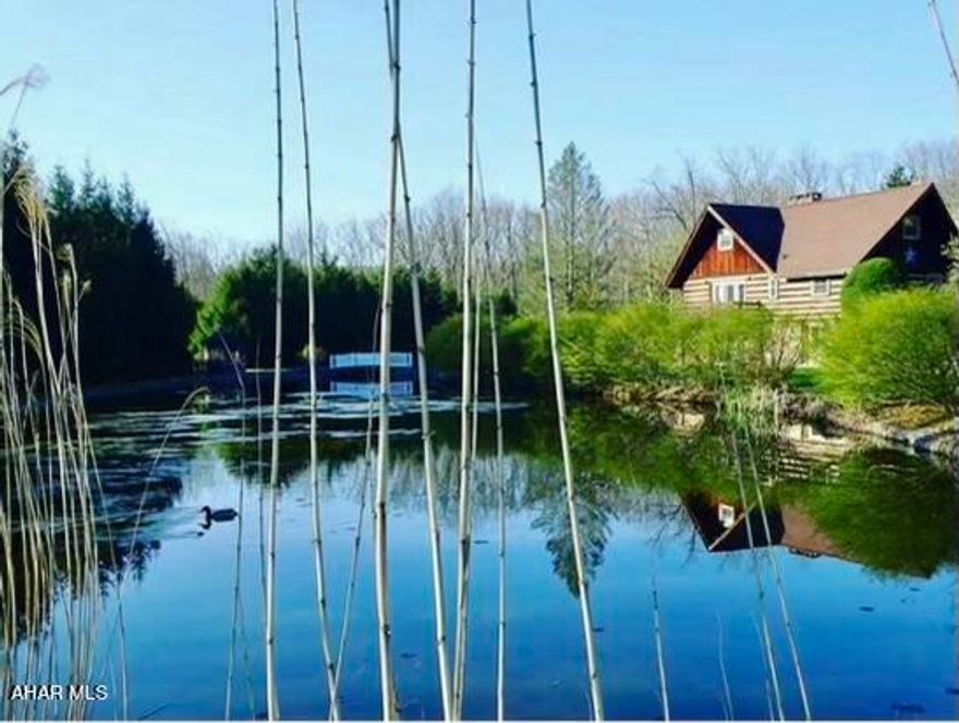 Not a bad seat in the house!
Say hello again to this one-of-a-kind log home. This hand crafted beauty has recently undergone some additional updates and is ready for its next owner.
A cozy retreat - the house is perfectly situated on 9.75 acres near the top of Patio Ranch Road with plenty of wildlife and seclusion, but enough room to entertain. Features include eat-in kitchen, 3 bedrooms - 1 on the main floor and 2 on second floor, recently updated bath, loft/study area, wood burning stove, TWO fireplaces!, detached two-story bank style garage, TWO ponds!, and serene views on all angles of the property. Wood burning fireplaces recently inspected. One fireplace is a see-through walk around design, the other is classic stone and steals the show in the rustic basement layout. Abundant wildlife present! Come see this charming home and prepare to fall in love.
